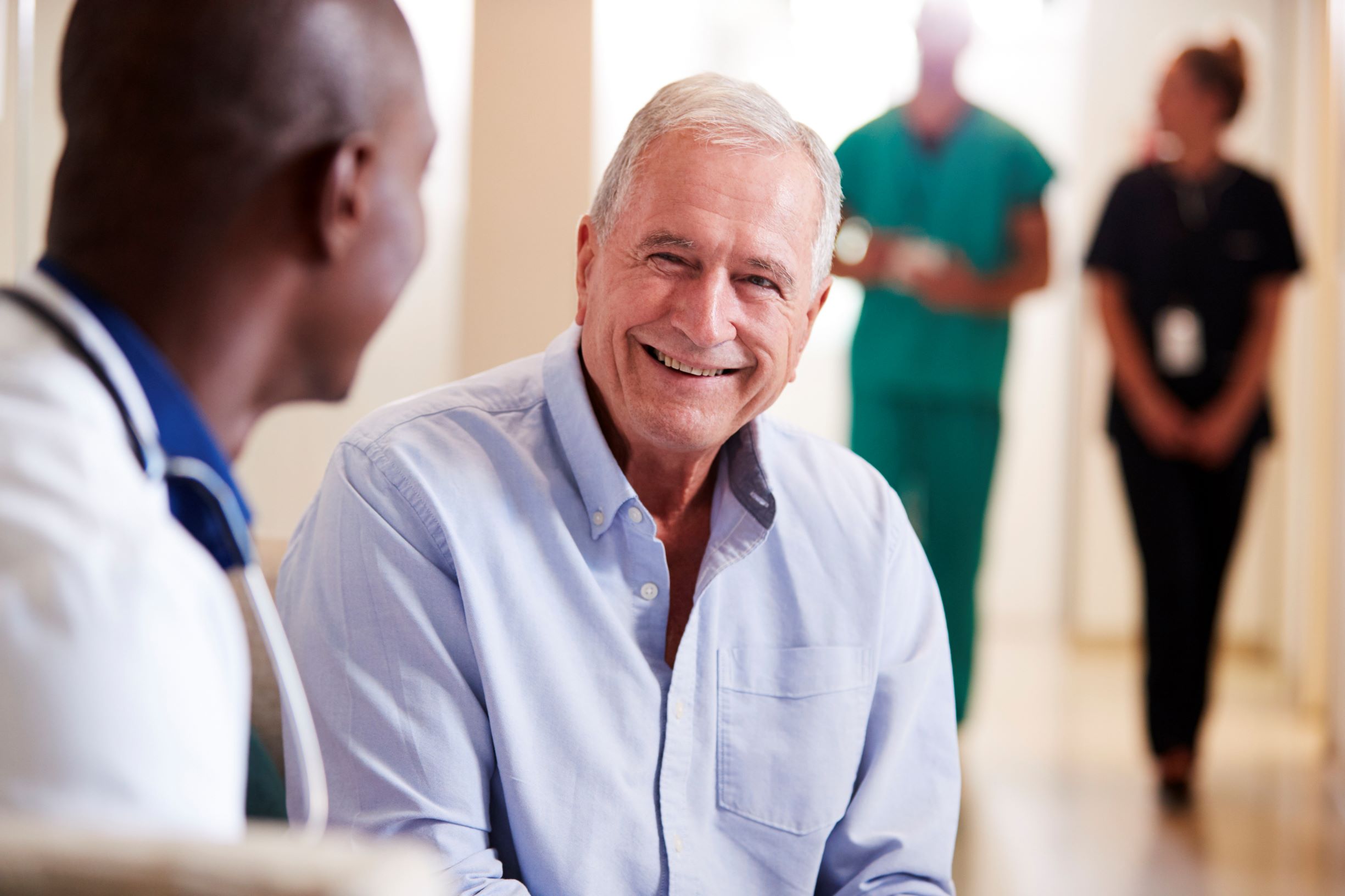 A senior man smiles as he speaks with his doctor. Your eye health can provide a glimpse into your heart health and help identify cardiovascular disease, diabetes, high cholesterol, and more.