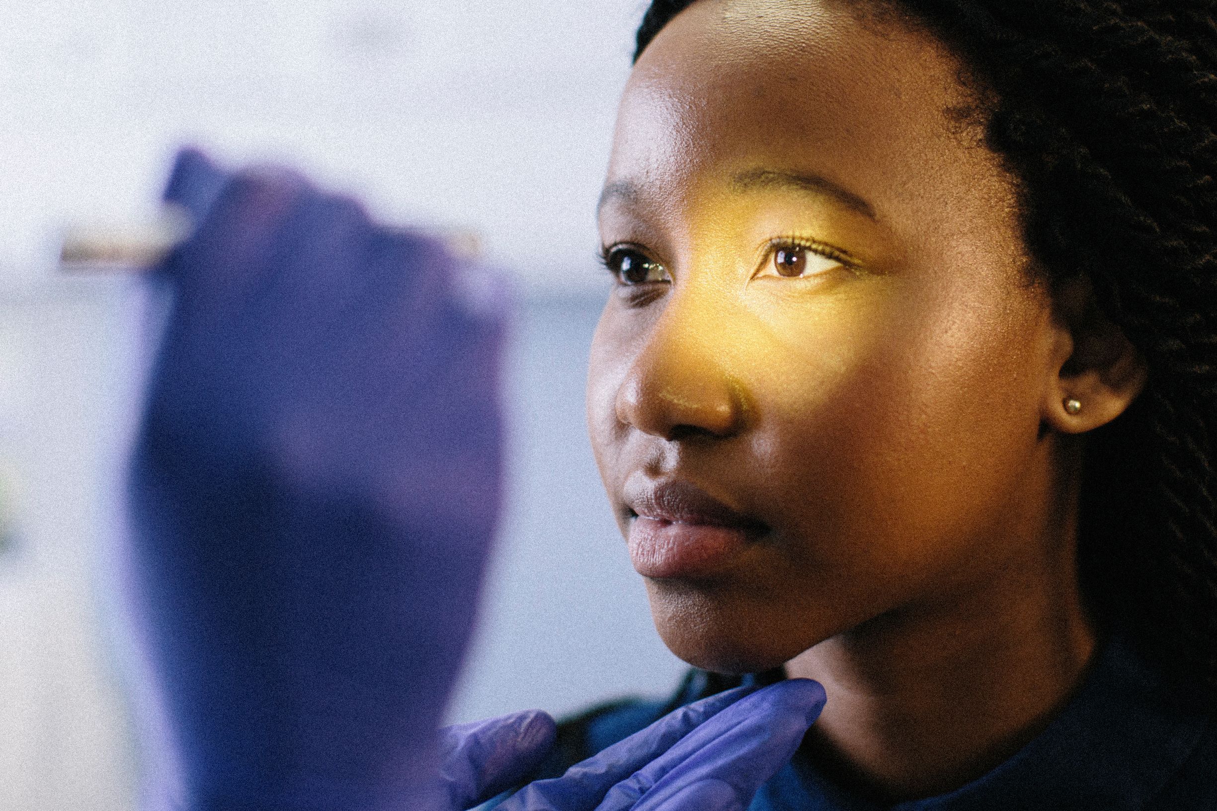 A light shines on a young woman during an eye exam. Eye health and heart health are related in several ways.