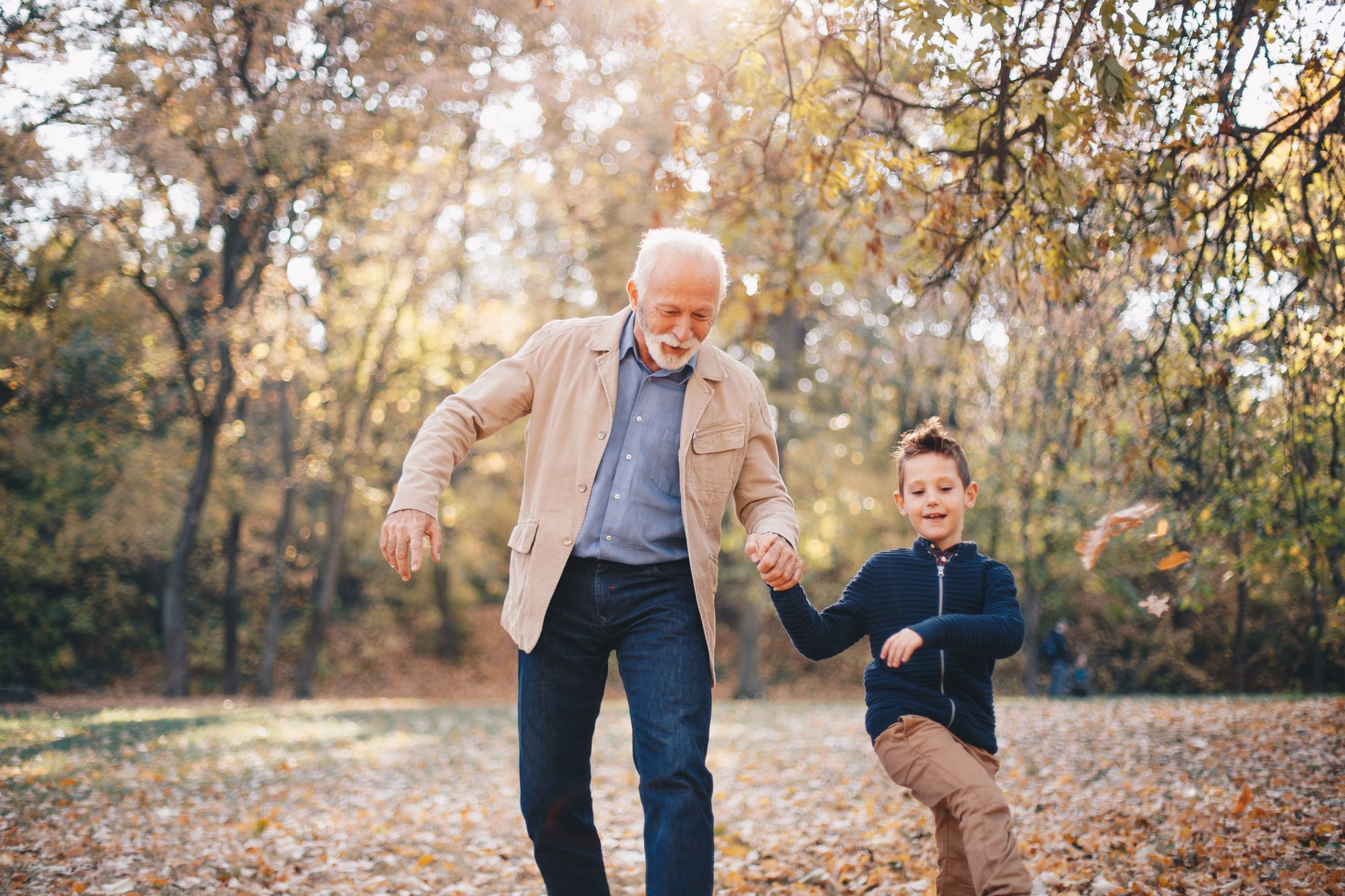 A man and his grandson kick up leaves as they walk in the park. Walking is an enjoyable and beneficial exercise for heart health. Taking children along can make the activity more fun, allowing you to smile and laugh with them while living in the moment.